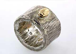 Grob mit der Finne geschmiedeter, breiter Silberring mit Goldelement